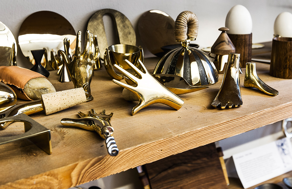Photo of Auböck's shop shelf showing various brass items including those with hand and foot shapes shot by OEN