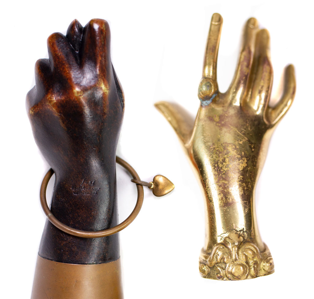 Back side comparison between the figa lighter's shape and an Auböck brass hand shaped paperweight.